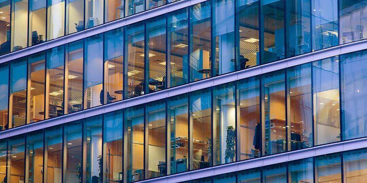 prédio empresarial espelhado com as luzes acessas