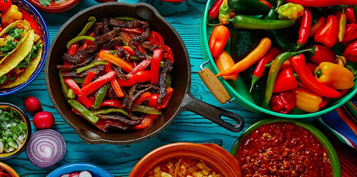 Panelas e tigelas cheias de pimentas, pimentões e comidas apimentadas