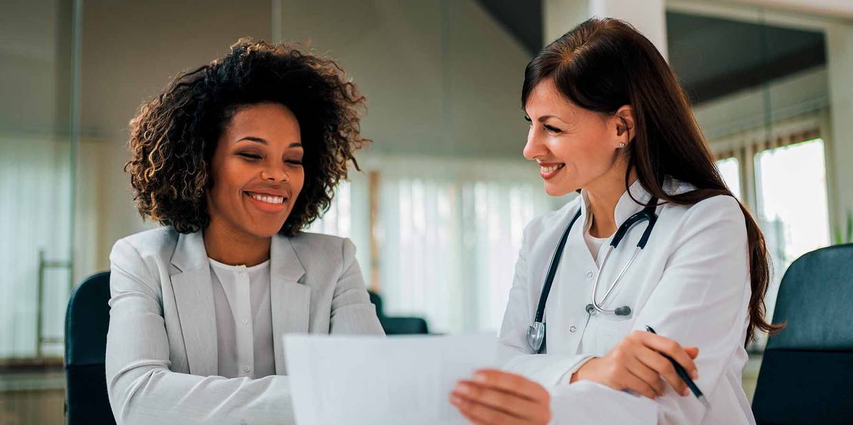 Duas mulheres médicas conversando a respeito de plano de saúde e convênio médico
