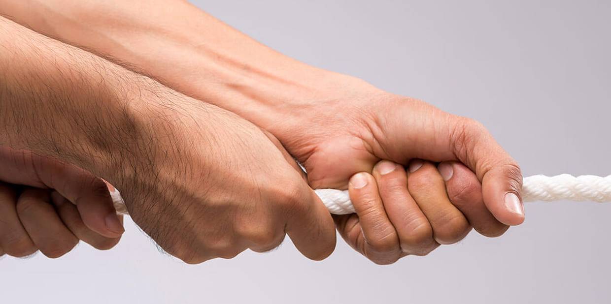 Três mãos seguram uma corda branca