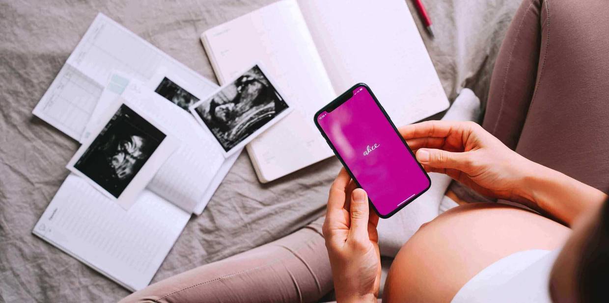 Mulher gestante segurando um celular