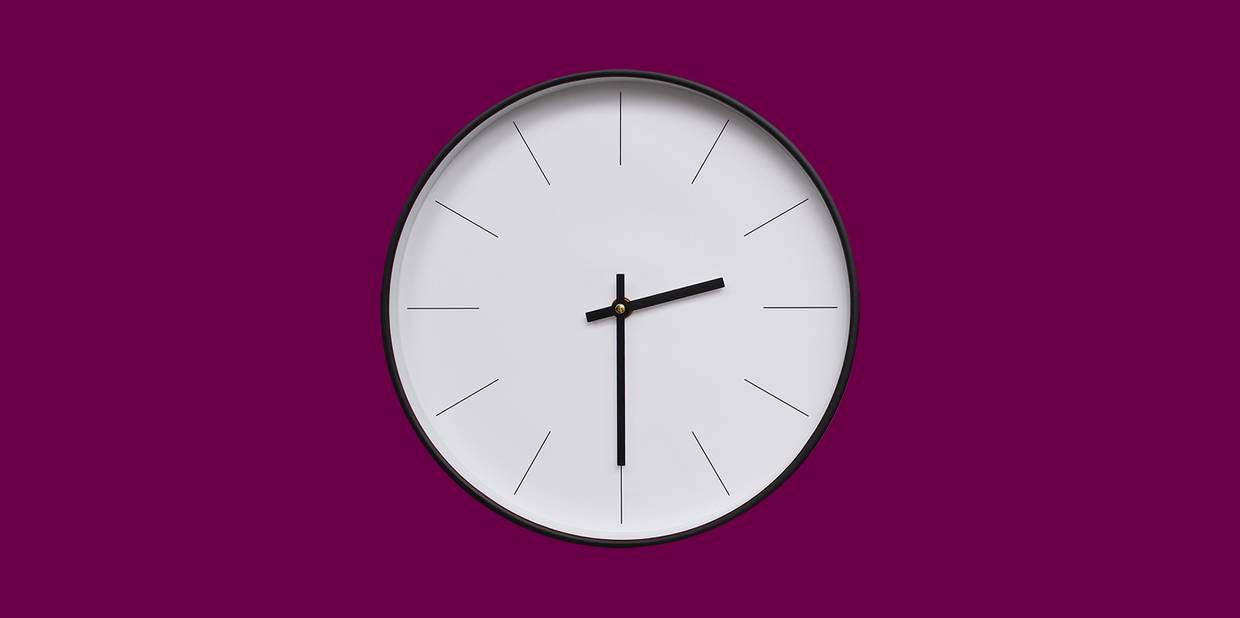Um relógio branco em um fundo beterraba indica horas fazendo referência à escala de trabalho