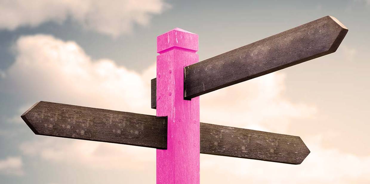 Totem de madeira apontando para dois caminhos possíveis