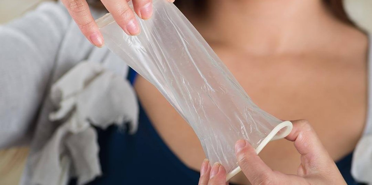 Pessoa segura camisinha feminina