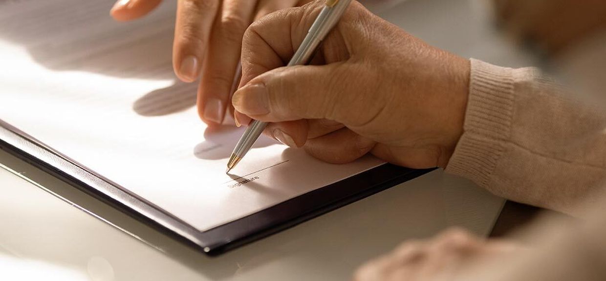 Mão segura caneta e escreve em papel