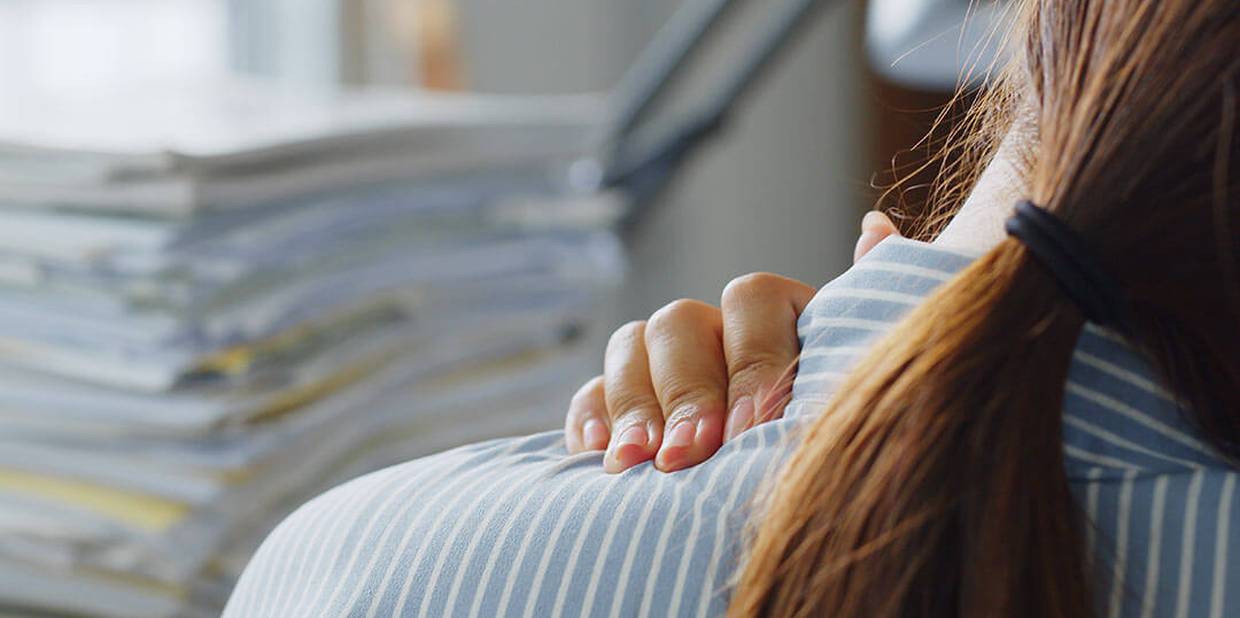 Pessoa toca no ombro como se estivesse com dor