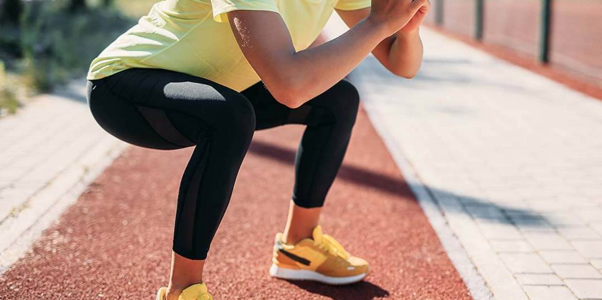 Pessoa faz agachamento durante treino