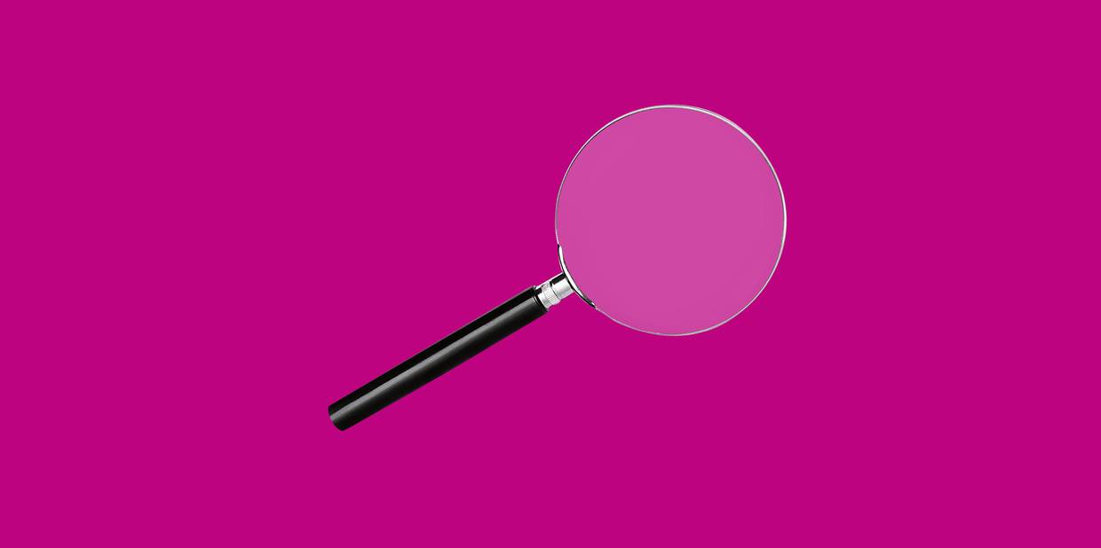 Uma lupa está em um fundo magenta