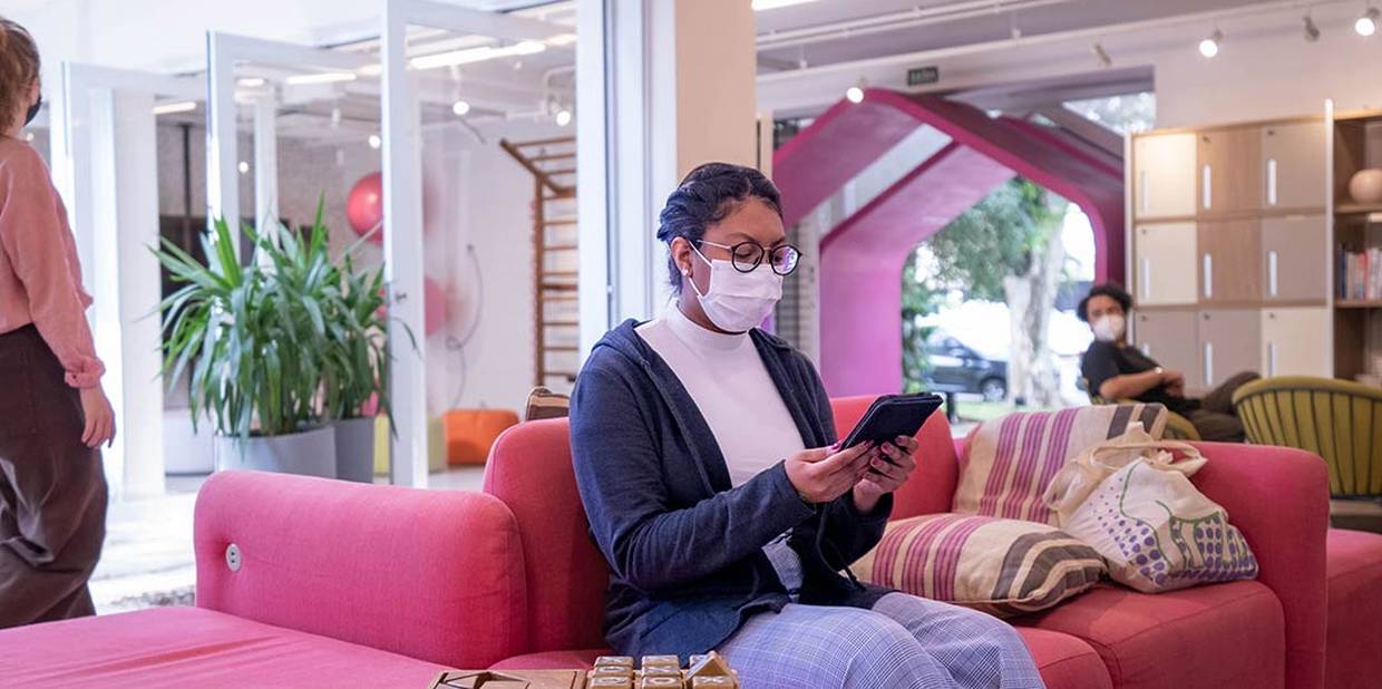 Membra da Alice sentada em um sofá da Casa Alice enquanto aguarda a consulta