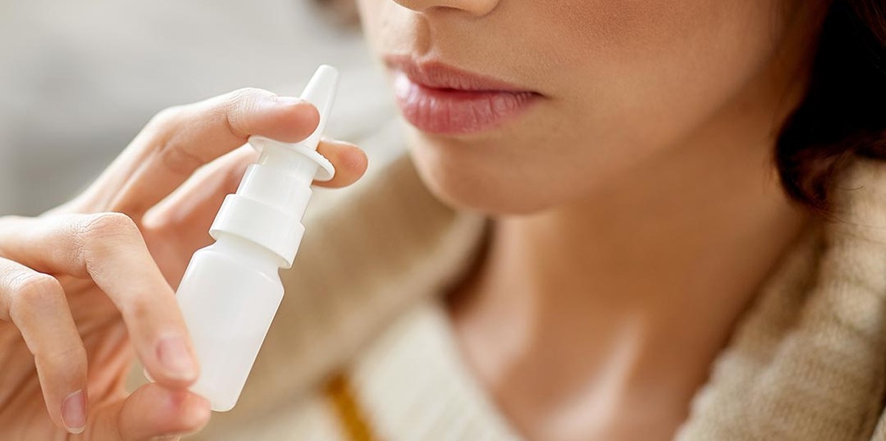 Mulher segurando um spray nasal